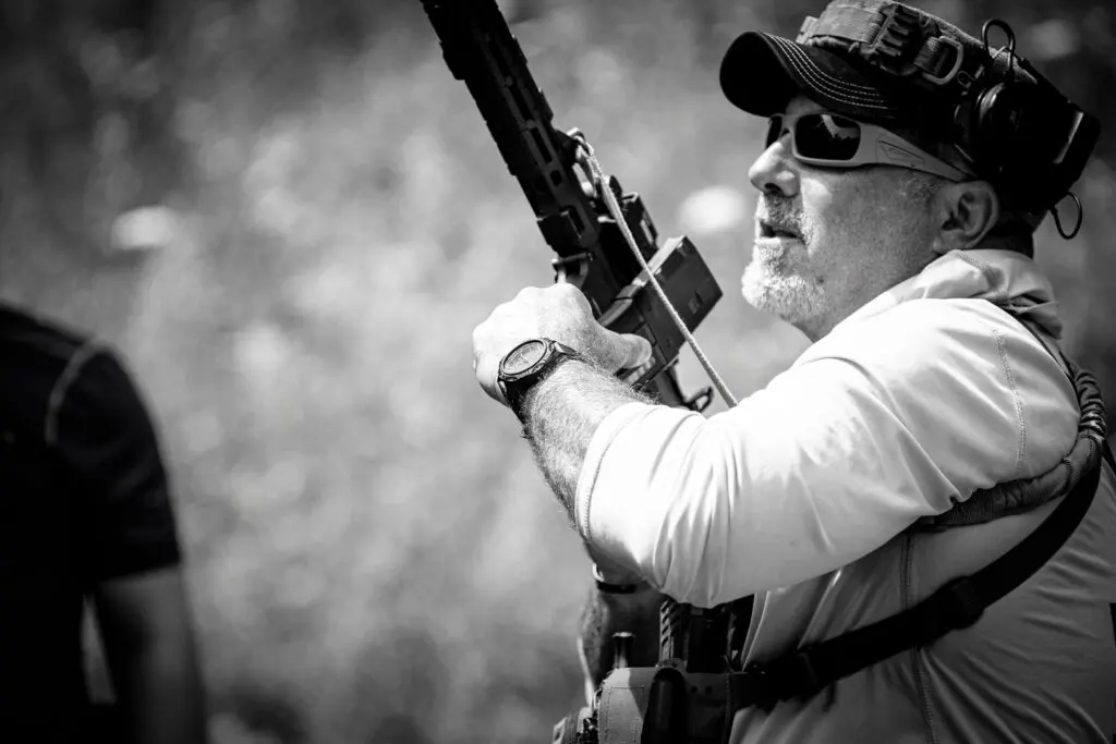 B AND W TAC LOAD A man holding a rifle in his hand.