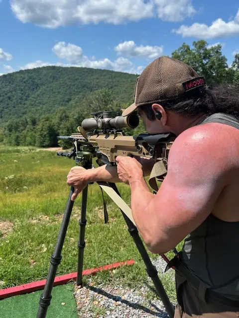 PR2 A man with a gun and rifle in the field.