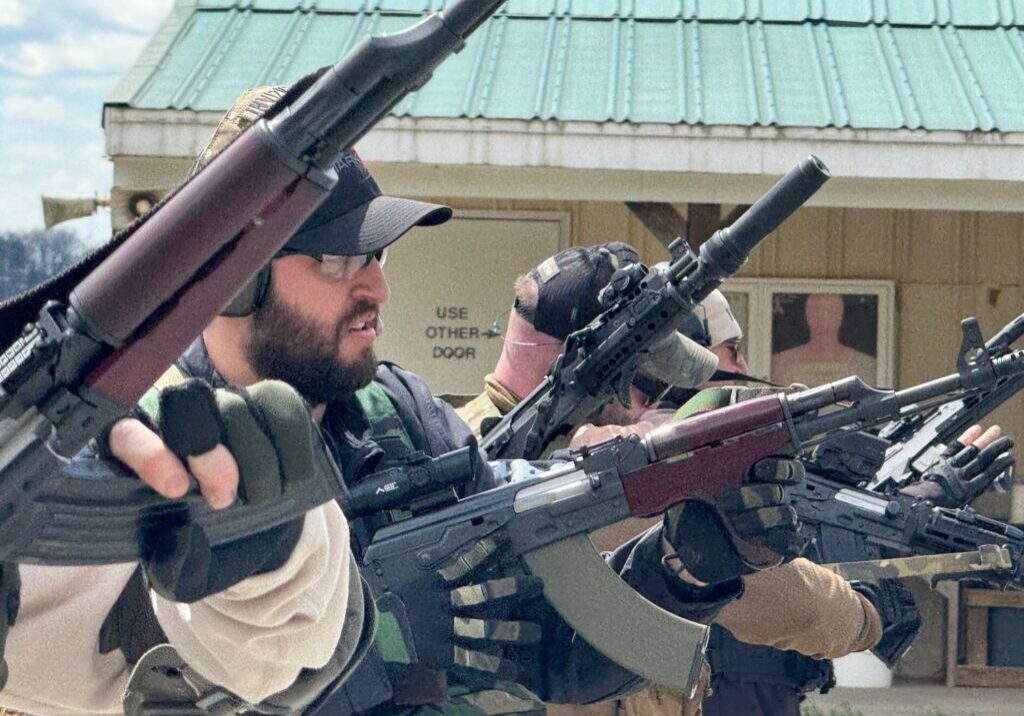 A group of men holding guns and rifles.